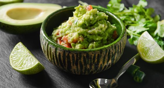 Bowl,With,Tasty,Guacamole,,Avocado,And,Lime,On,Dark,Background,